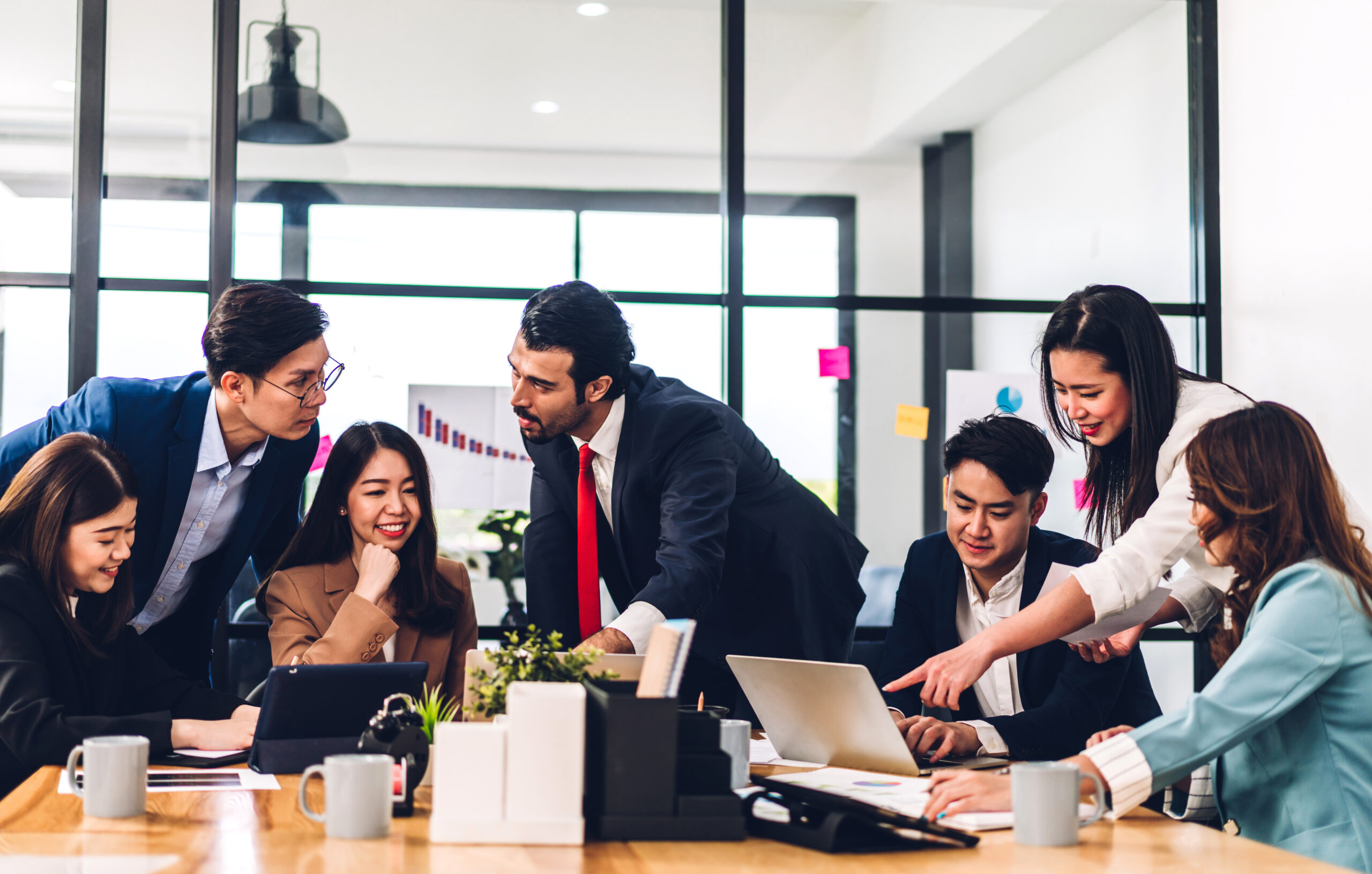 Group of professional asian business meeting and discussing strategy with new startup project.Creative business people planning and brainstorm with laptop computer in modern office.Teamwork concept