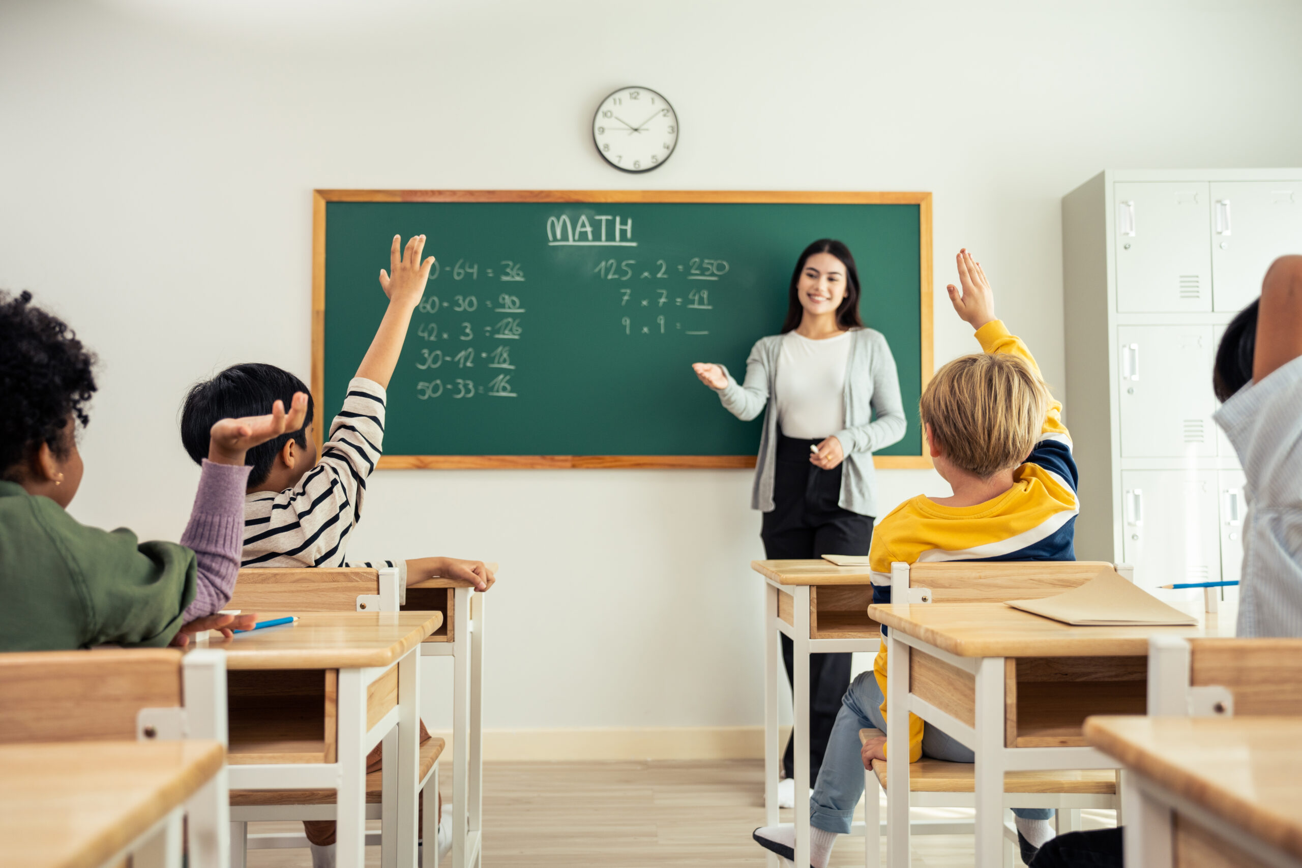 Group of student learn with teacher in classroom at elementary school. Attractive beautiful female instructor master explain and educate young children with happiness and fun activity at kindergarten.