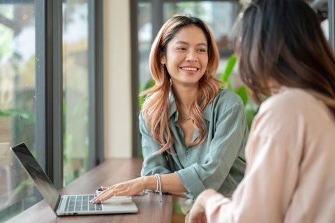 Happy,Asian,Woman,Talking,To,A,Friend,Aside,Laptop,While